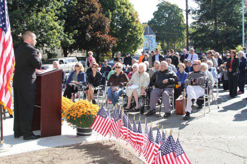 ON FRIDAY, SEPT. 19, the corner of Albion and Franklin streets was dedicated to the memory of World War II veteran Minor McLain. McLain, a history professor, was also a prisoner of war in Europe. An infantryman in the U.S. Army, he was awarded the Silver Star for gallantry and the Purple Heart. Friends and family attended the dedication ceremony, which took place not far from the Sgt. Harold O. Young VFW Post where McLain was a longtime member and official historian. Ryan McLane, district Veterans Affairs Officer spoke to the audience, which included McLain’s family seated in the front. In an adjacent photo, Mayor Robert J. Dolan speaks at the newly dedicated corner, with Ryan McLane behind him. (Donna Larsson Photos)