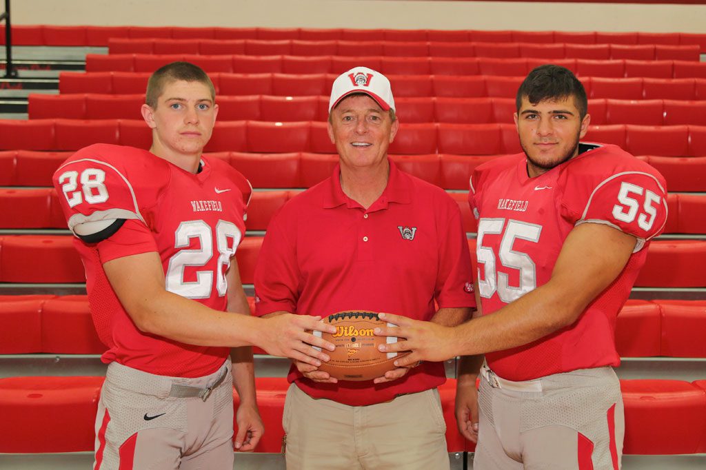 THE WARRIOR football team is off to a 1-1 start after its 32-14 triumph over Lynn English on Friday night at Manning Field. Leading the 2014 squad are senior co-captains Luke Martin (left) and Joe DiFazio (right). In the middle is Head Coach Mike Boyages. (Donna Larsson Photo)