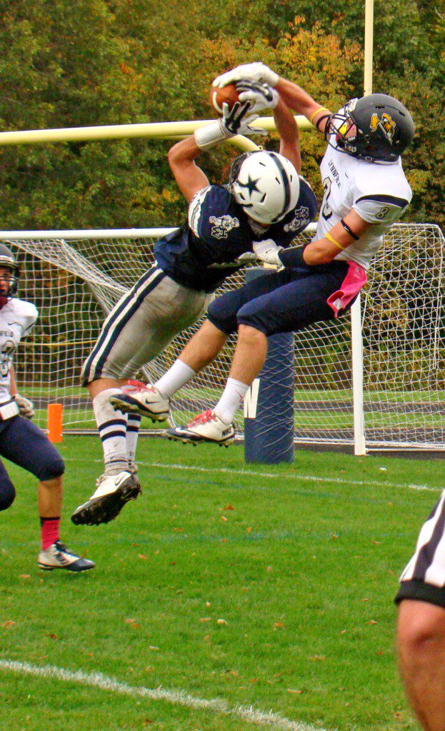 HIGH POINT of an undefeated season. Captain Cam Rondeau (8) leaps high to break up this potential TD pass in the end zone against Hamilton-Wenham, preserving the shut out in the CAL Baker Division championship game.        (Tom Condardo Photo)