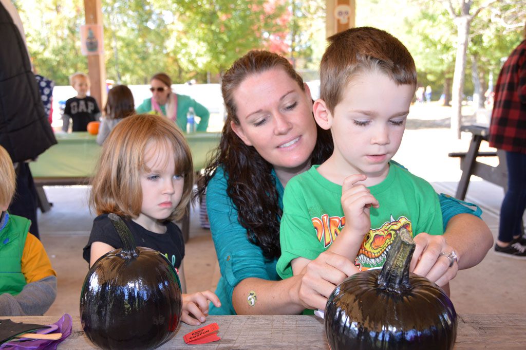 SANDY RUSSELL and her children Kara and Kingston had fun decorating pumpkins for Halloween at Parks and Recreation's annual Pumpkin Festival at Ipswich River Park. (Bob Turosz Photo)
