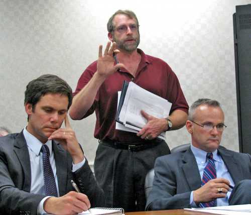 SHELTER’S DIRECTOR OF DEVELOPMENT Michael Glynn (left) and Attorney Brian McGrail listen as Matthew Jewett (standing) of Byron Street and a member of the Unitarian-Universalist Church addresses the impact that the abutting Brightview facility would have on the church. (Mark Sardella Photo)