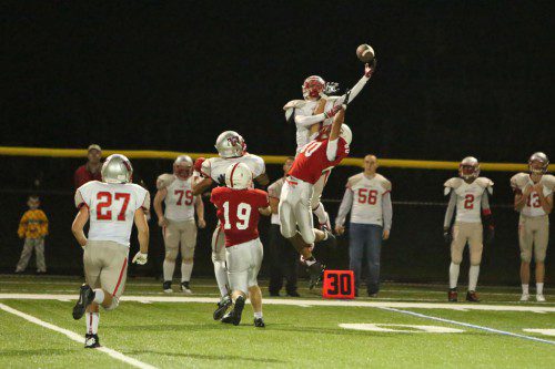 BRIAN DICKEY, a senior WR/DB, goes up for the ball against a Melrose player during a recent game. Last night against Watertown, Dickey had six receptions for 84 yards and a touchdown but Wakefield lost a high-scoring 40-22 contest at Victory Field. (Donna Larsson File Photo)