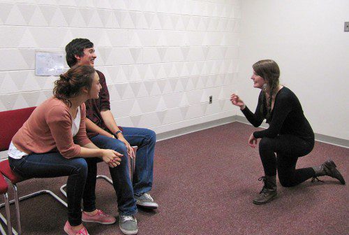 AS DIRECTOR of a play titled “Port” to be presented at Salem State University, Morgan Flynn, kneeling, is shown giving notes to actors Evan Parsons and Misha Barker for their roles as Danny and Racheal.