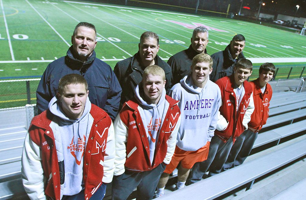 HISTORY IS remade as two generations of Melrose High School Red Raiders take the trip to Foxboro for Super Bowl. Members of the last MHS football team to go to Super Bowl in 1982 will see five of their sons make the trip this Saturday. They are: (pictured from left) John Mercer and son Zack, John McLaughlin and son Brian, Chris Hickey and son Jack, and George Karelas and sons Jake (l) and Luke (r). Melrose will take on Dartmouth on Sat. at 6:00 p.m. at Gillette Stadium and hope to earn their first Super Bowl victory. (Donna Larsson photo) 
