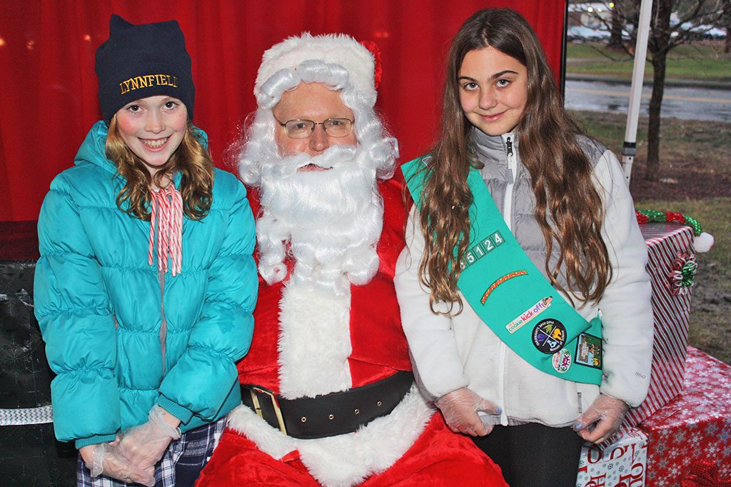 GIRL SCOUTS, from left, Abigail Travers and Courtney Cumming tell Santa what they want for Christmas during the 15th annual Tree Lighting ceremony on Dec. 6.                          (Dan Tomasello Photo)