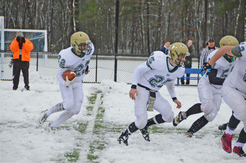 SNOW BOWL. Hornet Junior David Smith (22) hits the line behind the blocking of sophomore Matt McCarthy and others on the snow covered turf in Lynnfield on Thanksgiving morning. (Bob Turosz Photo)