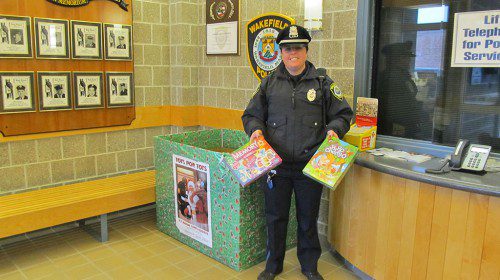 PATROL Officer Kelley Tobyne is shown holding the popular games “Memory” and “Hi-Ho Cherry-O” that were recently donated to the U.S. Marines Toys for Tots annual drive. (Gail Lowe Photo)