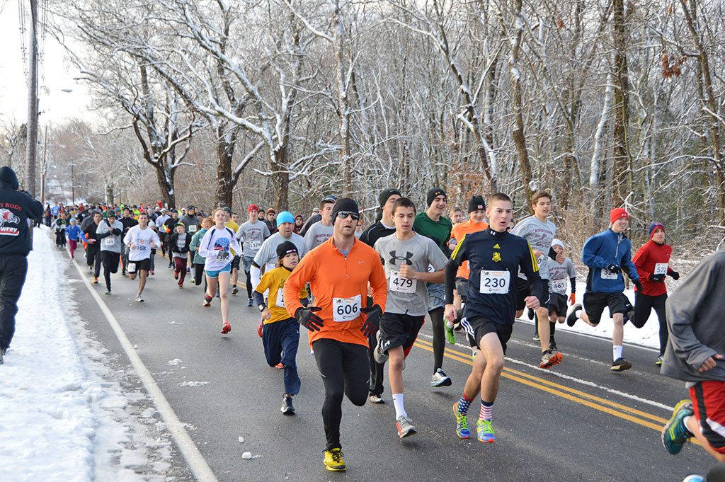 NEARLY 1,500 RUNNERS, a new course record, rumbled through the snowy streets of North Reading on Thanksgiving morning in the sixth annual Turkey Trot 5K race. (Bob Turosz Photo)