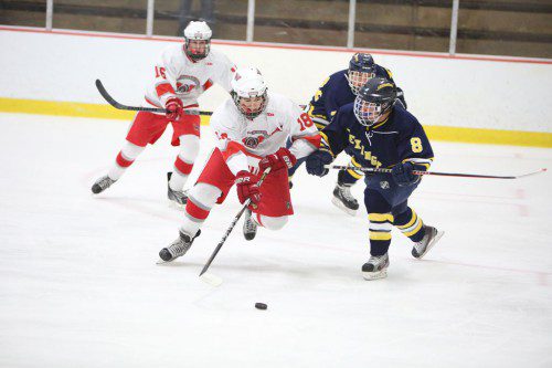 SENIOR FORWARD Andrew Patti (#18) goes for the puck with Lexington’s Cullen Bryant (#8) also in pursuit. Trailing the play is sophomore forward David Melanson (#16). (Donna Larsson Photo)