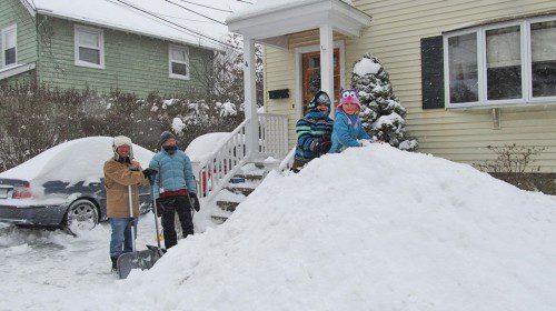 THE Bradley family on Cedar Place had fun shoveling and climbing a mountain of snow in front of their home. From left: Bob Bradley, Kim Bradley, Paige Bradley and Corinne Bradley.