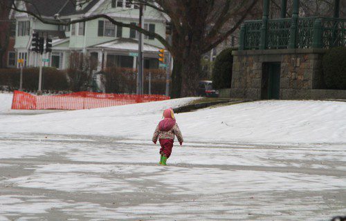 THIS YOUNGSTER BRAVED some pretty miserable conditions yesterday to get a better look at the Bandstand on the Lower Common. (Donna Larsson Photo)