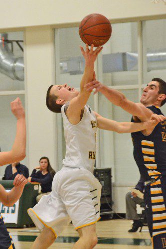 JUNIOR JUSTIN DOROSH was fouled on the arm by his Lynnfield opponent. He then hit one of two foul shots to tie the game at 52-52 with 5 minutes remaining. (John Friberg Photo)