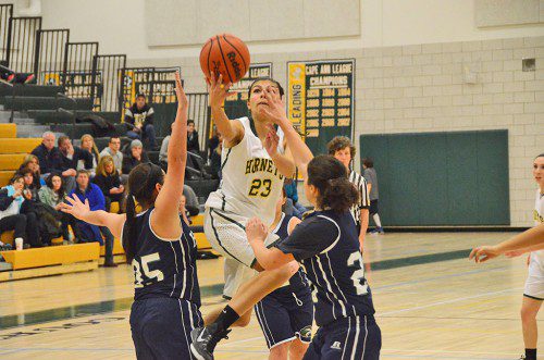 SOPHOMORE GUARD Kat Hassapis soars over the Essex Tech defense to score for the Hornets. (John Friberg Photo)