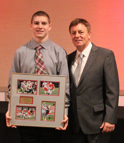 SENIOR LUKE Martin (left) was named the Warrior football team’s most valuable player and received a plaque at Wakefield’s recent awards banquet. On the right is Head Coach Mike Boyages.