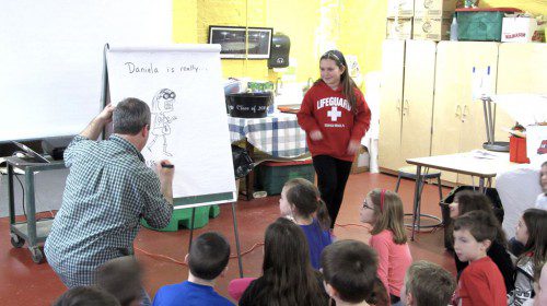 AUTHORFEST 2015, a program designed to promote writing — and sometimes illustrating — was held this week at the Greenwood and Dolbeare elementary schools. At the drawing easel, children's author and illustrator Marty Kelley is shown drawing a cartoon version of grade 2 student Daniela Doto. (Gail Lowe Photo)