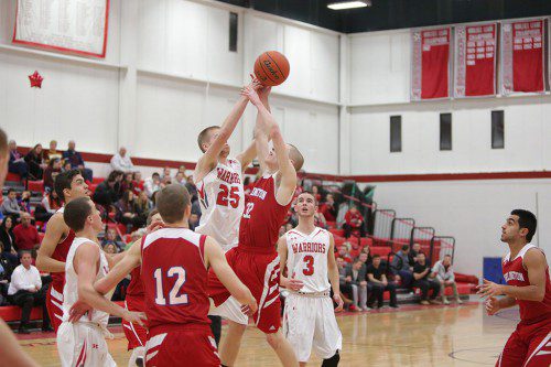 ANDREW AULD, a junior (#25), goes up for a rebound during Wakefield’s tournament clinching win against Burlington on Friday. Wakefield played Everett in an exclusionary game yesterday at the Charbonneau Field House and came up short in an 85-82 overtime thriller. (Donna Larsson File Photo)