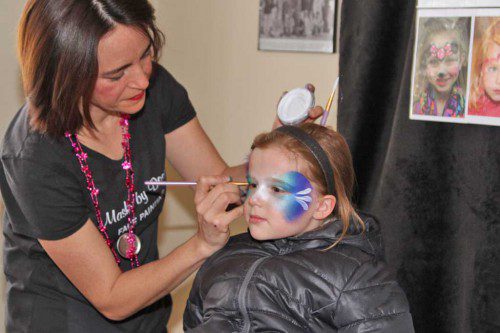EIGHT-YEAR-OLD Fiona Recene of Wakefield sits very still while getting a butterfly painted on her face during the 2015 Winter Festival held at Melrose’s Mount Hood Park and Golf Course Thursday, Feb. 19. (Donna Larsson Photo)