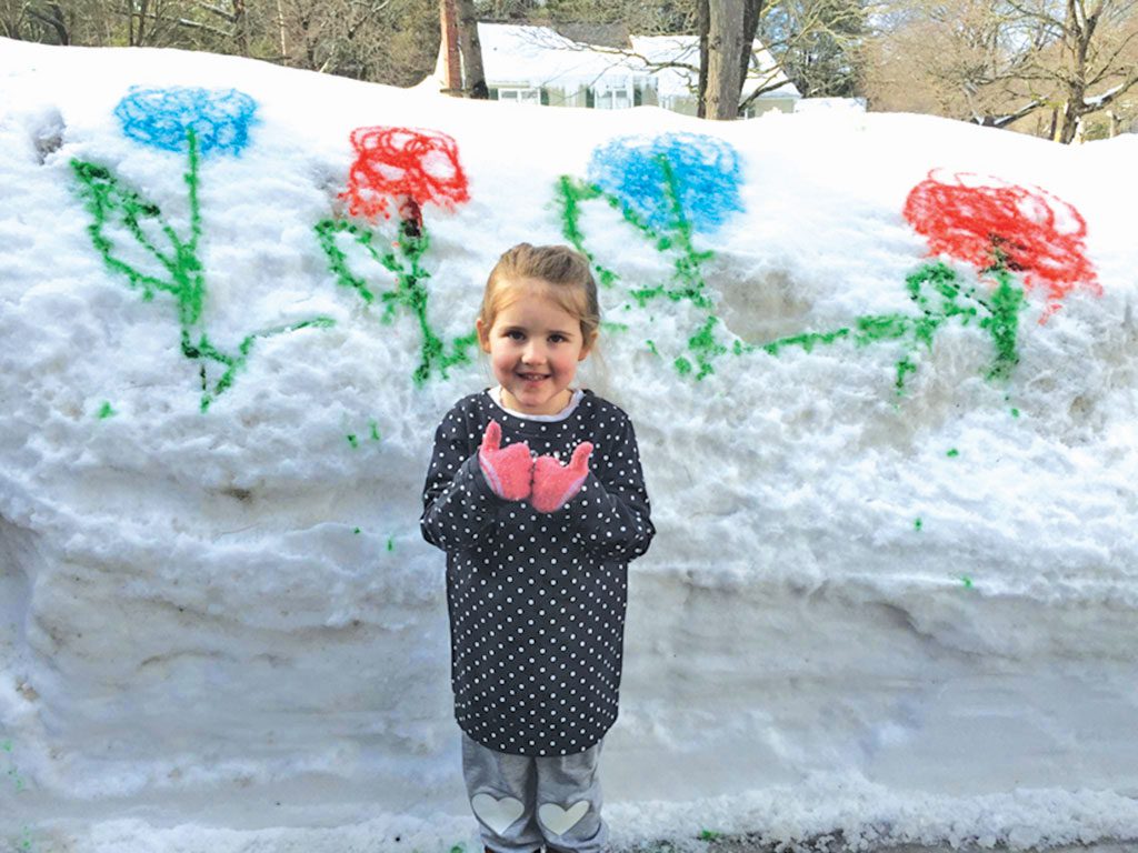 CAILEIGH REED, 4, gives two thumbs up for spring against a backdrop of colorful flowers she helped create. Huge snowbanks in the driveway of her nana's house provided the perfect canvas for Caileigh and her mom Catie to decorate. She is the granddaughter of Patty Glennon, 6 Saunders Rd. (Courtesy Photo)