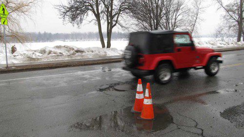 SOME potholes in town have been reported to the Department of Public Works. Traffic cones are then placed over reported potholes to alert drivers to avoid them. (Gail Lowe Photo)