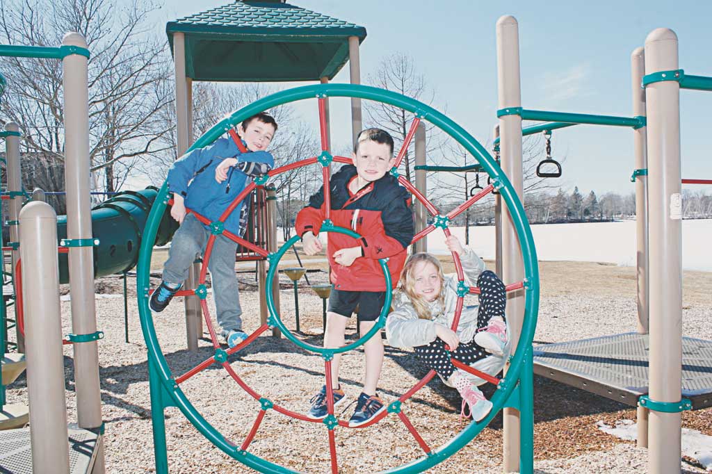 TESTING their agility skills while monkeying around on the climbing structure at the Spaulding Street Playground Wednesday are these active youngsters, from left: Eliot Baker, 6, Spencer D'Augusta, 7, and Grace D'Augusta, 9. (Maureen Doherty Photo)