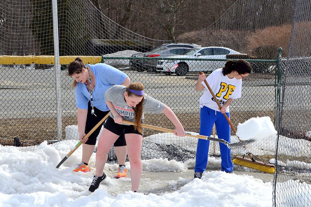 DESPITE THE HORRIBLE WINTER, spring sports are stirring and will soon get underway. Most of the high school track was pretty clear this week, with the exception of the events area, which needed to be shoveled. Above, track team members Elizabeth Flett, Johanna Walsh and Samantha Trulli shovel off the discus throwing area. (John Friberg Photo)
