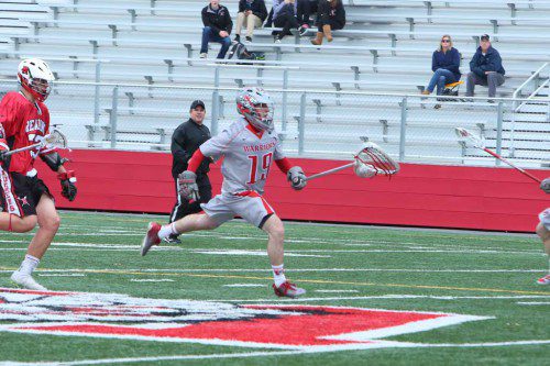 ALEX FLYNN, Wakefield's goalie, races up the field during a recent game. The Warrior boys' lacrosse team increased its record to 6-1 on the year with wins over Watertown and Stoneham. (Donna Larsson File Photo)