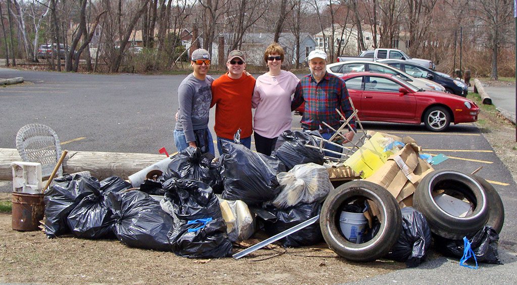 IN HONOR OF EARTH DAY, a group of about a dozen residents spent two hours on Saturday morning cleaning up around the Martins Pond neighborhood. Six of them picked up trash along the road and in the wetlands and removed two pickup truck beds full of garbage. The town DPW partnered with the volunteers and removed what they picked up. The other group spent their time beautifying the park and readying it for plantings that will be done this week. Above, from left: Caio and Scott Bechaz, Lori Lynes and Larry Soucie. Missing from photo: Jian Qiao and Jin Tao Ma. (Courtesy Photo)
