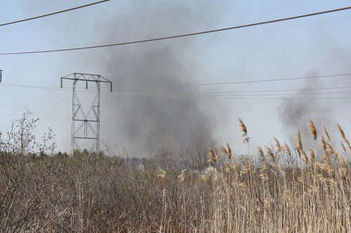 SMOKE FROM the five-alarm May 6 brush fire on the Lynnfield side of Reedy Meadow could be seen rising above the high tension wires from the end of Audubon Road in Wakefield. (Maureen Doherty Photo)