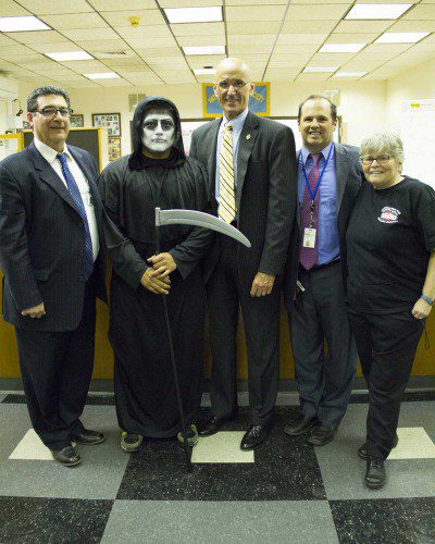 THE NORTHEAST Metropolitan Regional Vocational School’s chapter of Students Against Destructive Decisions (SADD) and the school’s Student Council co-sponsored and coordinated the 2015 “Grim Reaper Day” on May 14 to raise awareness of the dangers of distracted and impaired driving. Shown, from left: Superintendent Theodore Nickole, the Grim Reaper (senior Raul Ramos), Wakefield Chief of Police Rick Smith, Principal David DiBari and staff SADD Advisor Polly Coburn. (Photo by Brigette Gutierrez)
