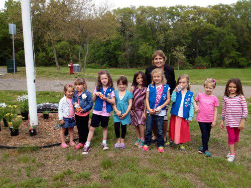 DAISY TROOP 69011 planted a perennial garden around the Doyle School flagpole Wednesday. Margo Perriello, principal of the Early Childhood Center, poses with troop members.