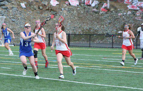 CATHY Francis, a junior (#14), carries the ball upfield during a recent game as teammate Kelsey Czarnota (#3) and Isa Cusack (#30) trail the play. Czarnota scored four goals and Cusack tallied one goal in Wakefield’s 15-5 win over Stoneham.  (Donna Larsson File Photo)