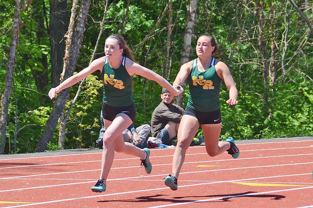 HORNET Rachel Hill (right) hands the baton to Juliette Nadeau (left) during the 4x100 meter relay at the CAL championships. (John Friberg Photo)