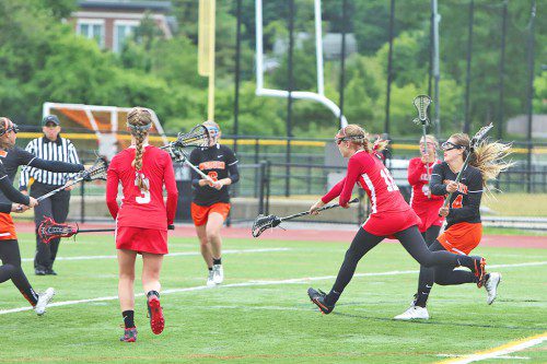JULIANNE BOURQUE (right) scored both Warrior goals in Wakefield’s 15-2 loss to Woburn in a Div. 1 North first round game yesterday at Connolly Memorial Stadium. On the left is Kelsey Czarnota (#3). (Donna Larsson Photo)