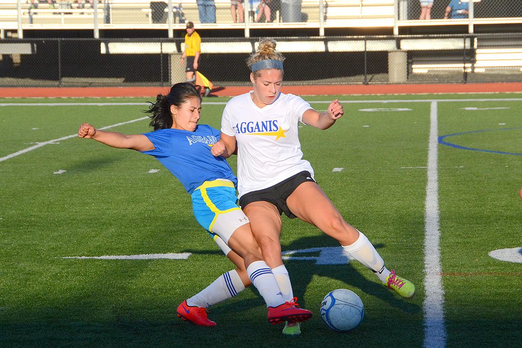 FORWARD Jess Duhaime (in white) fights for position against a North team opponent in the 20th annual Agganis All-Star game June 24. The South defeated the North 4-1. Duhaime will be attending the University of Tampa. She was one of 12 Pioneers named to Agganis All-Star teams this year in football, girls' soccer, baseball and boys' lacrosse.  (John Friberg Photo)