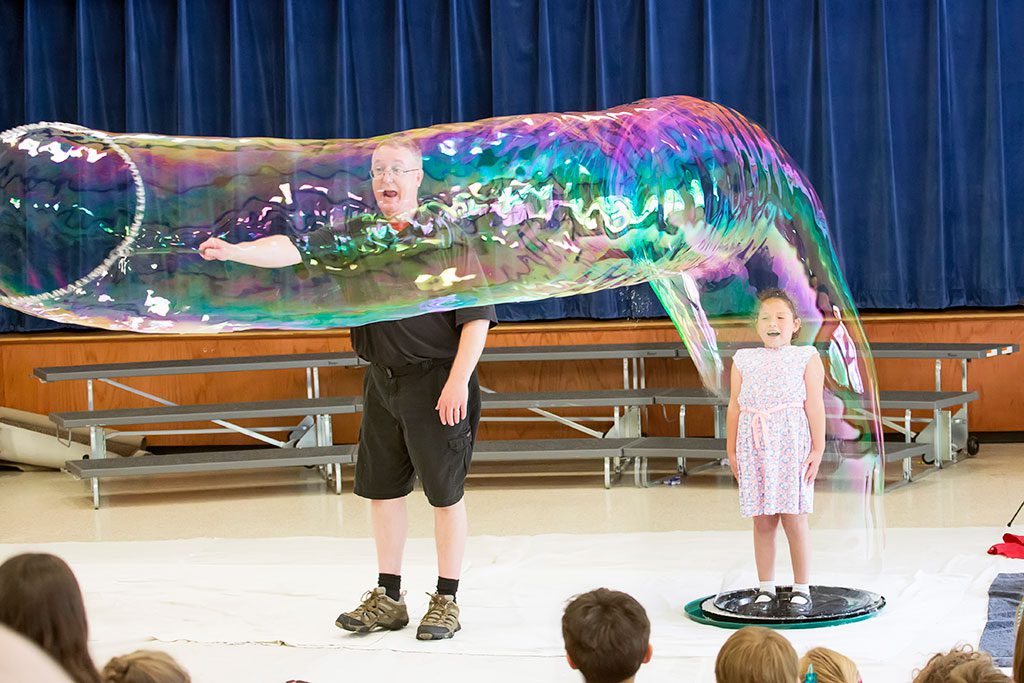 LITTLE SCHOOL kindergarten and preschool students enjoyed a fantastic enrichment program when Keith Johnson visited and shared the secret life of bubbles with the kids. Above, student Talia Colon will never forget the view from inside this massive bubble. (Suzanne Baker Photo)
