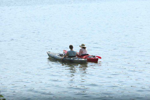 THIS COUPLE took advantage of the stillness of Lake Quannapowitt yesterday and pulled their kayaks next to each other as they rested from the heat.