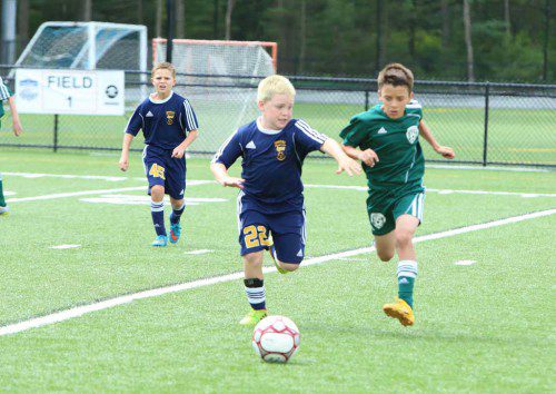 LYNNFIELD AVENGER Dylan Damiani (left) protects the ball on a breakaway from North Reading Stingers opponent Giovanni Pagliuca during the East West U10 International Friendly boys' soccer tournament. (Donna Larsson Photo)
