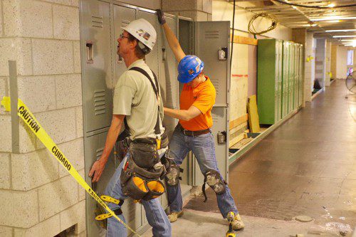 CONSTRUCTION WORKERS install lockers in the new middle school. (Geof Simons Photo)