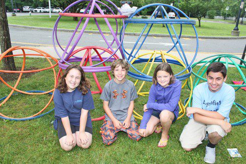 RECREATION STATION campers, from left, Mary Gray, Charlie Kane, Maddie Sieve and counselor Joe Fabrizio proudly display the Hula Hoop Monument they created at the Summer Street School playground on July 10. (Dan Tomasello Photo)
