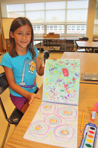 LAUREN LANE proudly displays two pieces of artwork from the sketchbook she created during the Monet Camp she attended at SOFA Camp, sponsored by Lynnfield Community Schools and held at LHS. (Maureen Doherty Photo)
