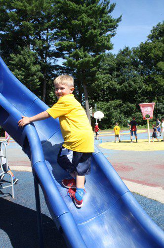 SUMMER slides away. Phoenix Billings scrambles up the twisty slide at the Summer Street School. Summer vacation is rapidly sliding into the past as the town's students prepare to return to the classroom next Tuesday. (Maureen Doherty Photo)