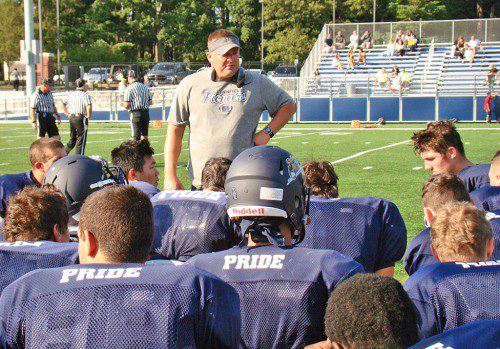 HEAD COACH Neal Weidman addresses the troops at halftime of the recent Northeast scrimmage. With a 54-man varsity roster, the Pioneers have the depth to continue the team's winning tradition under Weidman. (Tom Condardo Photo)