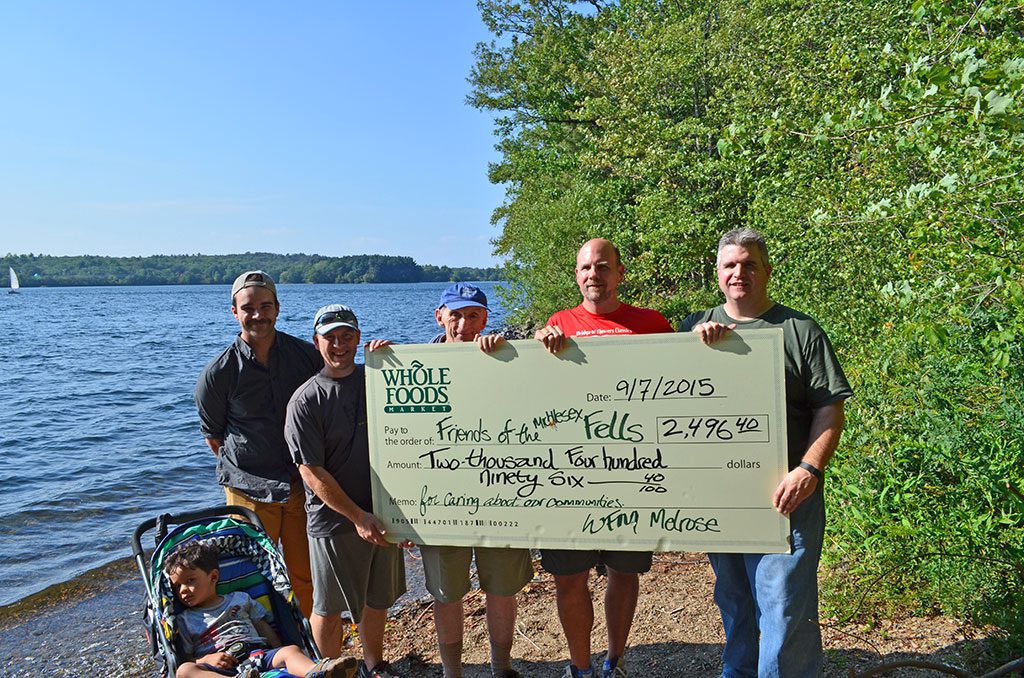 WHOLE FOODS IN MELROSE presented a check to the Friends of the Middlesex Fells Reservation this past Labor Day weekend. Whole Foods kicked off the Friends of the Fells summer fundraising season in June with a 5 percent giveback day. Todd McInnis, Whole Foods manager, is now running the VERT Race Series Fells Fest this Sunday, September 13, and raising additional money to close out the Friends of the Fells Summer Campaign. Featured in the photo from left to right are Neil Ram Anderson (age 2), Dylan Campbell, marketing and Community Relations Manager Whole Foods Melrose, Neil O. Anderson, Executive Director Friends of the Middlesex Fells Reservation, Mike Oliver and Rich Sanford from the Friends of the Middlesex Fells Reservation Board of Directors, and Todd McInnis, Manager of Whole Foods Melrose.