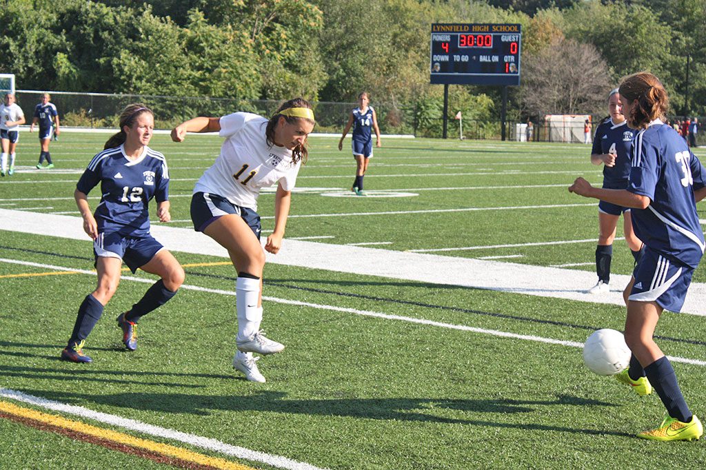 SENIOR Olivia Skelley (11) advances the ball while fighting for possession sandwiched between two Triton opponents in the Pioneers' 4-1 victory over the Vikings. (Maureen Doherty Photo)