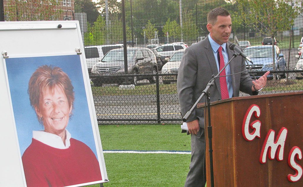 NEW GALVIN MIDDLE SCHOOL Principal Adam Colantuoni speaks alongside a portrait of his mentor Dr. Paula Mullen at the dedication of the new Dr. Paula M. Mullen Field at the Galvin Middle School. (Mark Sardella Photo)