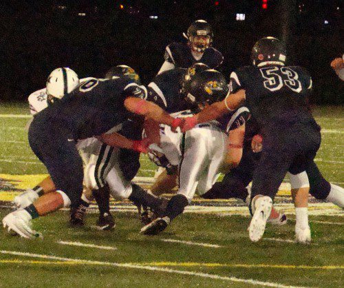 SENIOR SALUTE. Seniors Spencer Balian (76), Drew Balestrieri (44), CJ Finn (11) and Trevor Caswell (53) engulf H-W runner Christos Meimeteas for a two-yard loss in the first quarter. (Tom Condardo Photo)