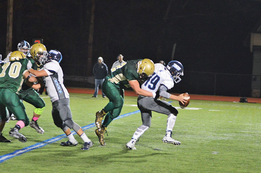 WELCOME TO NORTH READING. The Hornet defense was ferocious all night and was the key to North Reading's 14–7 victory over Triton. Above, junior Bob O'Donnell has the Viking quarterback all wrapped up. (Bob Turosz Photo)