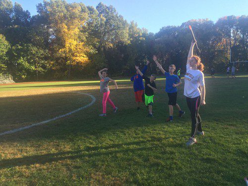 LHS SENIOR Marie Norwood demonstrates the proper positions for holding and throwing a javelin to a group of middle school athletes at track camp. (Courtesy Photo)