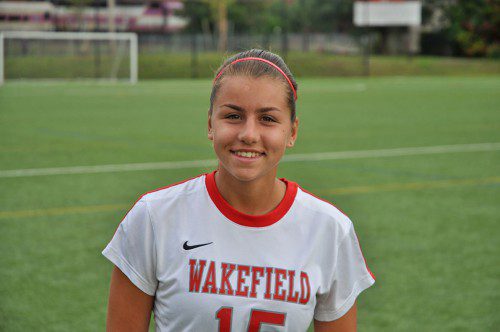 COMMTANK would like to congratulate freshman Christina LeBlanc for being named Wakefield Memorial High School Varsity Girls’ Soccer Player of the Week. Christina had just returned to full participation following a concussion. In both games last week against Burlington and Watertown, she reappeared as physically fit, skilled and determined as ever. At the start of the season, Christina was moved from the forward position to the outside right-midfield spot. Her defensive and offensive skills are equally as developed and threatening for an opponent, an essential quality at the midfield especially. Her transition to this position was an enormous gain for the team as a whole, while still being able to use her on the forward line. Last week, Christina played with intensity unmatched by most. Coupled with this intensity is a tremendous ability to read the game and be involved in activity up and down the sideline. Defensively, this freshman player recovers with speed and can identify when to contain and when to go in for the tackle. It is extremely difficult for a player from another team to beat her one-on-one. Offensively, she is smart about using the space around her whenever it is available or taking one or two touches before finding one of her teammates to pass to. After Christina releases the ball she is immediately on the move, wasting no time to re-involve herself in her team’s possession. This puts her in the middle of many give and go combinations and overlapping runs. She has the skill of players at the higher levels to “keep her head on a swivel” as she is continuously looking around her to find her opponent, her team and her next possible move. She is never satisfied with the last play, she always wants more and better from herself. Christina’s hard play is matched by her well defined skills and as a freshman, the Warriors are very excited about her three future years as a member of the varsity team. (Brian Cusack Photo)
