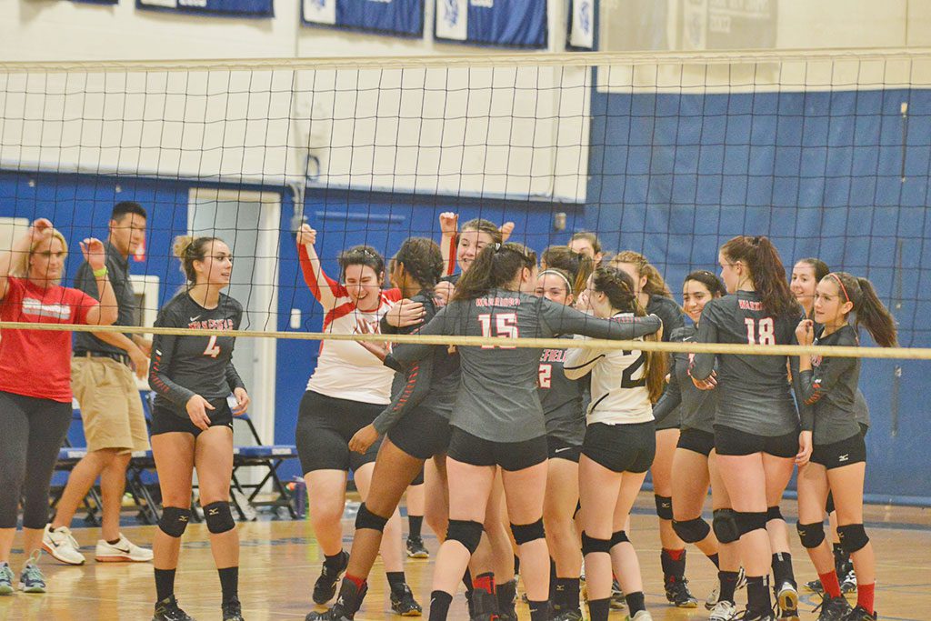THE WMHS girls' volleyball team celebrates its come from behind 3-2 victory over Stoneham last night at Stoneham High School. The Warriors won their first league match of the season.
